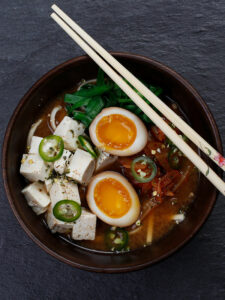 Logotyp för Ramen ”Miso” med sojapicklat ägg, kimchi, five spicekryddad tofu och udonnudlar