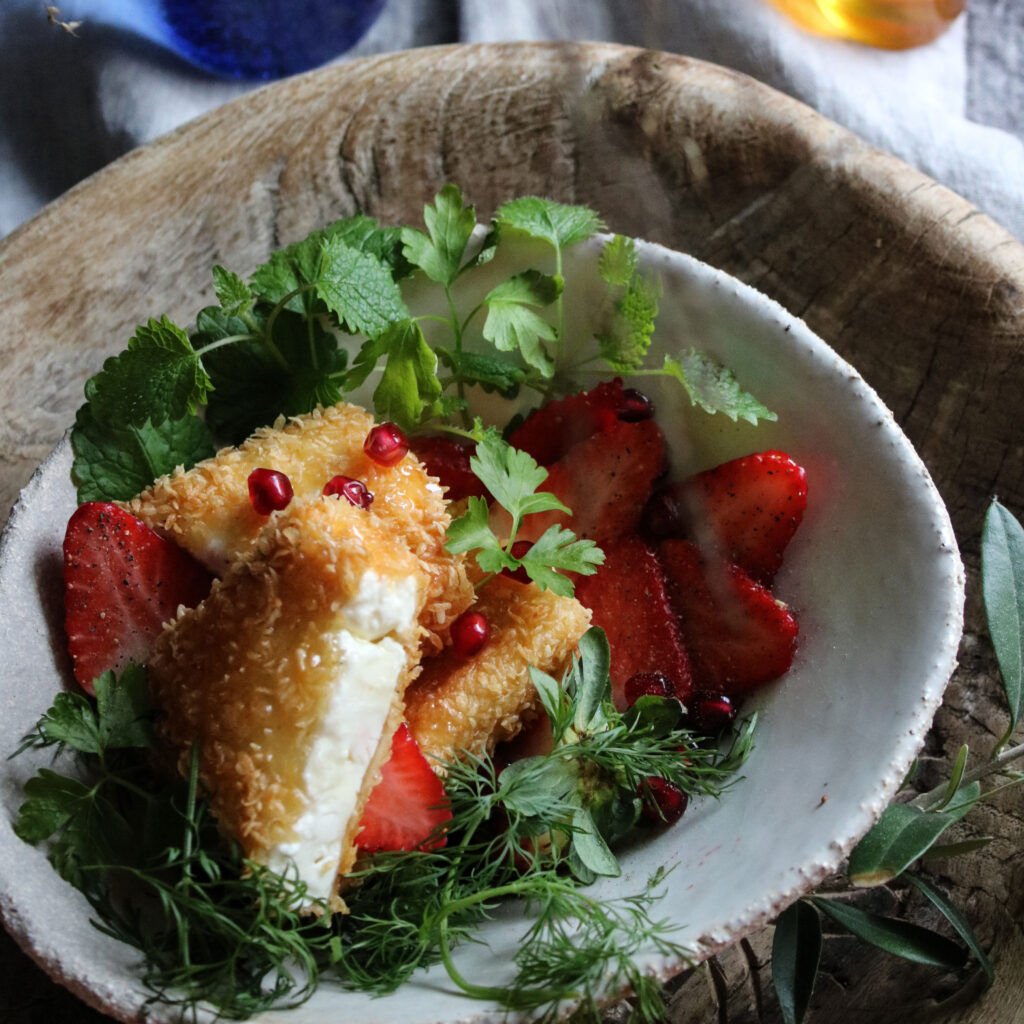 Friterad, pankopanerad fetaost med chilihonung serveras ört- och jordgubbssallad